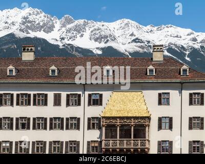 INNSBRUCK, AUSTRIA - 5 MAGGIO 2016: L'iconico tetto dorato in piastrelle di rame nella città vecchia di Innsbruck, Austria. Le cime innevate delle Alpi Foto Stock