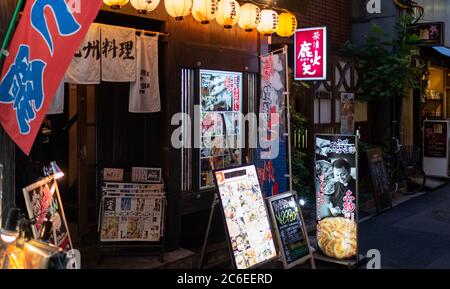 I vicoli della vecchia scuola del quartiere di Shimbashi o yokocho pieni di minuscoli ristoranti, pub e negozi, Tokyo, Giappone al tramonto. Foto Stock