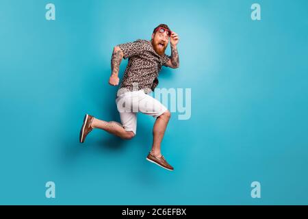 Vista a tutta lunghezza del corpo del suo bell'attraente pazzo funky overjoyed allegro uomo allegro che salta correre velocemente isolato brillantezza intensa Foto Stock