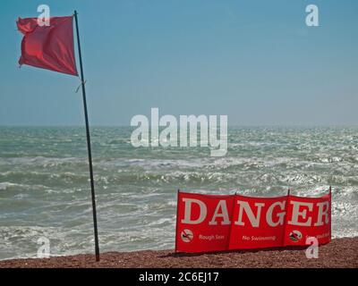 Una bandiera rossa vola per avvertire le persone di andare in mare a Brighton Foto Stock