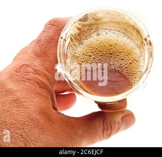 Bicchiere di birra schiumosa scura a mano maschile - scena chiave alta Foto Stock