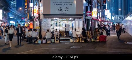 Folla di persone al vicolo di Yurakucho pieno di piccoli ristoranti, pub e izakaya di notte, Tokyo, Giappone. Foto Stock