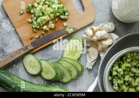 Cucina estiva con verdure fresche e crude, preparazione di zuppa di yogurt freddo Foto Stock