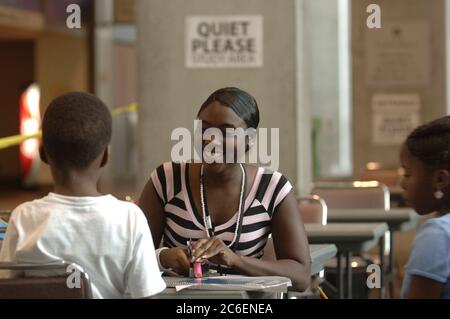 Austin, Texas USA, 14 settembre 2005: Shimeka Monson, studentessa della University of Texas at Austin, aiuta gli scolari della Louisiana a fare i compiti al rifugio di soccorso dell'uragano Katrina dell'Austin Convention Center. ©Bob Daemmrich Foto Stock