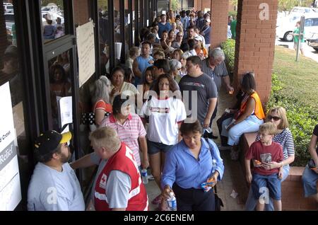 Austin, Texas USA, 1 ottobre 2005: Gli evacuati dal Texas orientale e dalla Louisiana meridionale affollano il marciapiede di fronte al centro di soccorso della Croce Rossa americana a nord di Austin. Alcune parti dei due stati sono ancora senza servizi settimane dopo l'uragano Katrina e l'uragano Rita. ©Bob Daemmrich Foto Stock