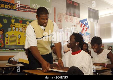 Pflugerville, Texas USA, 13 settembre 2005: L'insegnante del primo anno della Park Crest Middle School Cedric Welch, ex residente di New Orleans, aiuta Fenwick Watson a evacuare il suo secondo giorno di lezione nel Texas centrale dopo aver evacuato la Louisiana prima dell'uragano Katrina. Fenwick è una delle centinaia di studenti della Louisiana che frequentano la scuola nella zona di Austin. ©Bob Daemmrich Foto Stock