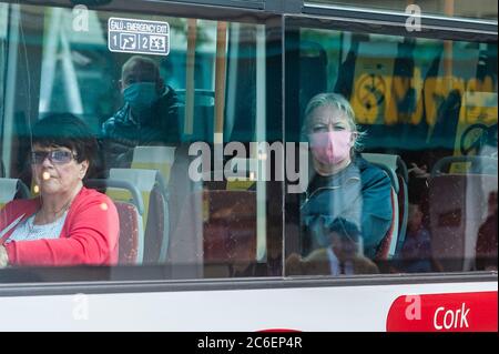 Cork, Irlanda. 9 luglio 2020. Una donna indossa una maschera facciale su un autobus Eireann in Cork città oggi, mentre un passeggero collega viaggia senza una maschera. L'uso di maschere facciali sui mezzi di trasporto pubblico è diventato obbligatorio in Irlanda lunedì 29 giugno. Credit: Notizie dal vivo di AG/Alamy Foto Stock