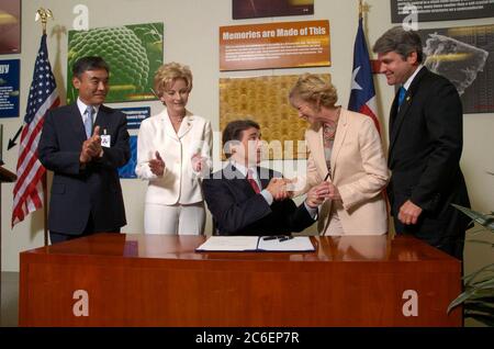 Austin, Texas USA, 13 giugno 2005: Il governatore del Texas Rick Perry (al centro, seduto) firma un disegno di legge che stimola gli investimenti nell'industria high-tech del Texas. La firma del disegno di legge avviene presso l'impianto di produzione di semiconduttori Samsung da 1,3 miliardi di dollari nella periferia nord di Austin. Da sinistra a destra ci sono il direttore dello stabilimento H.K. Park, la Rep. Di Stato Jeanne Morrison, il Governatore Perry, il Senatore di Stato Florence Shapiro e il Rep. Michael McCaul. ©Bob Daemmrich Foto Stock