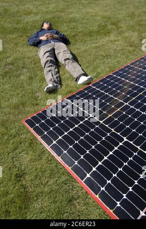 Medicine Hat, Alberta Canada, 26 luglio 2005: Il pilota riposa vicino alla sua auto solare mentre si ricarica al sole durante la North American Solar Challenge, una gara di auto solari di 2.500 km da Austin, Texas, a Calgary, Alberta Canada. L'evento della durata di 10 giorni comprende 22 squadre universitarie e universitarie provenienti da Stati Uniti e Canada. ©Bob Daemmrich Foto Stock