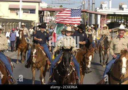 Eagle Pass Texas USA, marzo 2005: Il senatore statunitense Kay Bailey Hutchison of Texas cavalca con cavalieri locali attraverso il ponte internazionale sul fiume Rio grande da Eagle Pass a Piedras Negras in Messico. La corsa fa parte del suo tour che promuove il nuovo El Camino Real National Historic Trail. ©Bob Daemmrich Foto Stock