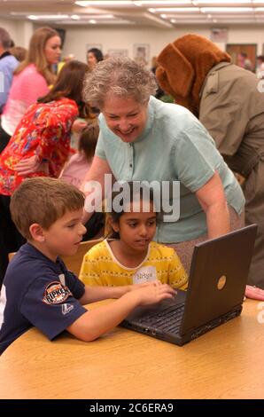 Austin, Texas USA, 19 aprile 2005: I bambini di seconda elementare guardano il programma di sicurezza Internet per bambini sui computer portatili della biblioteca scolastica durante l'evento di avvio per il "Cyber-Guardian for the Internet Age: Faux Paw the Techno Cat." ©Bob Daemmrich Foto Stock