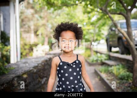 Ritratto di una giovane bella ragazza afroamericana in piedi con fiducia in ambiente urbano. Foto Stock