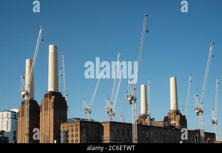 Gru sopra la centrale elettrica di Battersea, disegnata da Sir Giles Gilbert Scott, sviluppo di proprietà che guarda sopra il fiume Tamigi a Londra, Regno Unito. Foto Stock