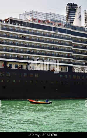 VENEZIA, ITALIA - 21 SETTEMBRE 2014: La nave da crociera attraversa la laguna veneta e la piccola barca sul suo fronte al mattino. Più di 10 milioni di turisti visitano Foto Stock