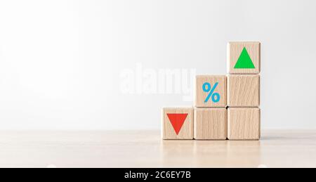 Blocchi di cubi di legno con simbolo percentuale di segno e direzione verso l'alto e verso il basso. Foto Stock