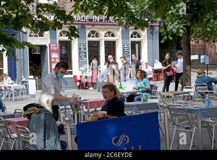 Edimburgo, Scozia, Regno Unito. 9 luglio 2020. 17 gradi e sole che incoraggiano le persone a uscire a cenare e bere nel centro della città presso i vari pop up cafe al Waverley Mall e i ristoranti nel Grassmarket che hanno posti a sedere all'aperto disponibili. Oltre al personale d'attesa che indossa maschere e visiere, la nuova normale sembrava piuttosto normale al occasionale onlooker che passa. Dal 15 luglio a partire da questa data, i ristoranti, i bar e i caffè potranno servire i clienti all'interno, anche in base alle norme di distanza fisica e ai consigli sulla salute pubblica. Foto Stock