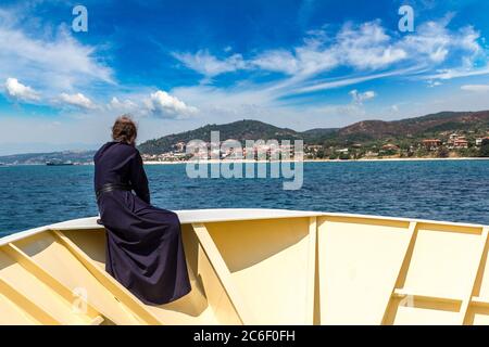 Il vecchio monaco guarda le montagne Athos su una nave in una giornata estiva Foto Stock