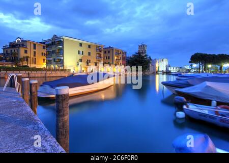 Marina di Sirmione, Lago di Garda, con alberghi moderni e Castello Scaligero sullo sfondo. Foto Stock