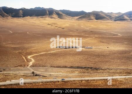 Fattoria di pietra con case nel mezzo della sabbia. Viaggio in auto nel deserto. Uzbekistan Foto Stock