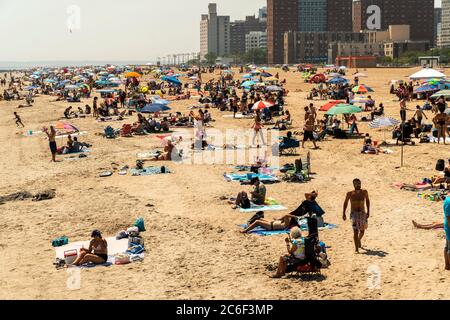 Migliaia di beachgoers osservano generalmente le distanze sociali mentre cercano di battere il calore e l'umidità a Coney Island a Brooklyn a New York nel fine settimana lungo di giorno di Indipendenza, domenica 5 luglio 2019. (© Richard B. Levine) Foto Stock