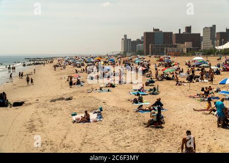 Migliaia di beachgoers osservano generalmente le distanze sociali mentre cercano di battere il calore e l'umidità a Coney Island a Brooklyn a New York nel fine settimana lungo di giorno di Indipendenza, domenica 5 luglio 2019. (© Richard B. Levine) Foto Stock