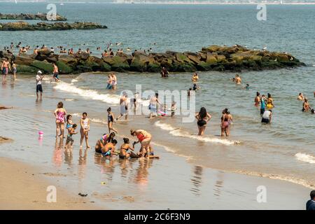 Migliaia di beachgoers osservano generalmente le distanze sociali mentre cercano di battere il calore e l'umidità a Coney Island a Brooklyn a New York nel fine settimana lungo di giorno di Indipendenza, domenica 5 luglio 2019. (© Richard B. Levine) Foto Stock