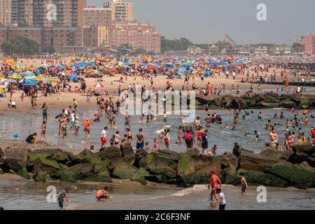 Migliaia di beachgoers osservano generalmente le distanze sociali mentre cercano di battere il calore e l'umidità a Coney Island a Brooklyn a New York nel fine settimana lungo di giorno di Indipendenza, domenica 5 luglio 2019. (© Richard B. Levine) Foto Stock