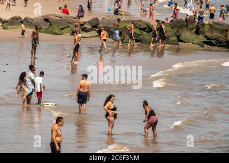 Migliaia di beachgoers osservano generalmente le distanze sociali mentre cercano di battere il calore e l'umidità a Coney Island a Brooklyn a New York nel fine settimana lungo di giorno di Indipendenza, domenica 5 luglio 2019. (© Richard B. Levine) Foto Stock