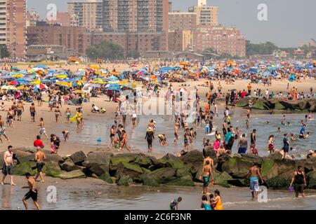 Migliaia di beachgoers osservano generalmente le distanze sociali mentre cercano di battere il calore e l'umidità a Coney Island a Brooklyn a New York nel fine settimana lungo di giorno di Indipendenza, domenica 5 luglio 2019. (© Richard B. Levine) Foto Stock