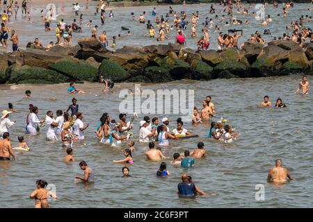 Migliaia di beachgoers osservano generalmente le distanze sociali mentre cercano di battere il calore e l'umidità a Coney Island a Brooklyn a New York nel fine settimana lungo di giorno di Indipendenza, domenica 5 luglio 2019. (© Richard B. Levine) Foto Stock