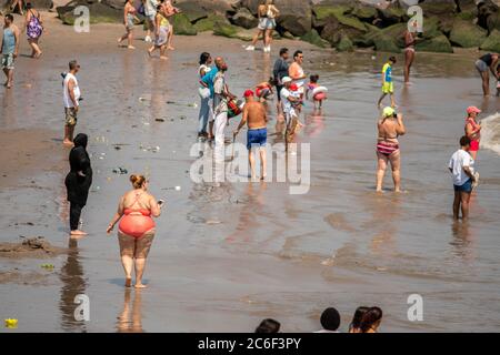 Migliaia di beachgoers osservano generalmente le distanze sociali mentre cercano di battere il calore e l'umidità a Coney Island a Brooklyn a New York nel fine settimana lungo di giorno di Indipendenza, domenica 5 luglio 2019. (© Richard B. Levine) Foto Stock