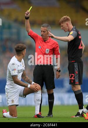 Il ben White (a sinistra) di Leeds United riceve una carta gialla dall'arbitro Darren Bond durante la partita del campionato Sky Bet a Elland Road, Leeds. Foto Stock