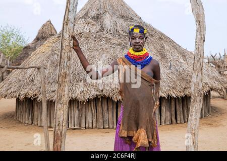 Donna nera con faccia dipinta della tribù Karo / Kara di fronte alla capanna nel villaggio, bassa valle Omo, Debub Omo zona, Etiopia meridionale, Africa Foto Stock