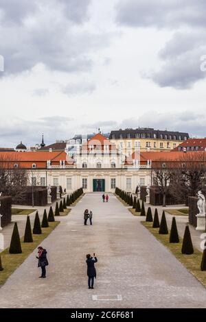 Vienna, Austria - 6 marzo 2017: Vista della gente Passeggiate nel Giardino Belvedere con il Palazzo inferiore sullo sfondo Foto Stock