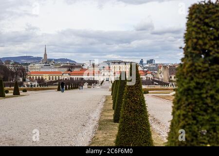 Vienna, Austria - 6 marzo 2017: Vista della gente Passeggiate nel Giardino Belvedere con il Palazzo inferiore sullo sfondo Foto Stock