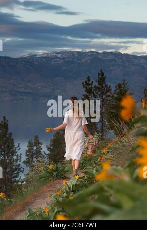 Donne che corrono in un campo di fiori Foto Stock