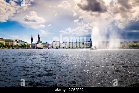 idilliaco panorama orizzontale del lungomare di binnenalster nella città vecchia di amburgo con vista sul jungfernstieg con il municipio e il monumento a san nicola Foto Stock