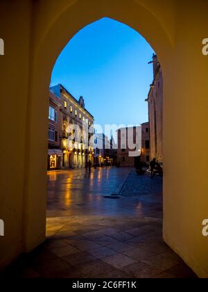 Pittoresca vista illuminata nel crepuscolo attraverso un arco fino alla Placa de la Catedral, vicino alla consell insular de menorca a ciutadella Foto Stock