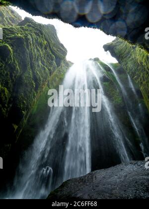 Foto a basso angolo della rinfrescante cascata nascosta di Gljufrabui con gocce sull'obiettivo della fotocamera in una misteriosa grotta islandese vicino a Storidalur Foto Stock