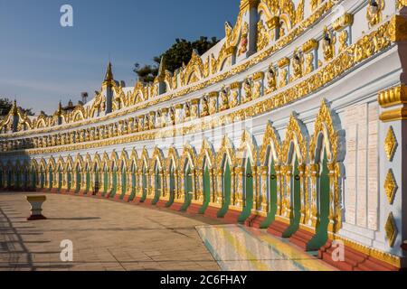 Sagaing, Myanmar - 16 gennaio 2019: La facciata della Pagoda della Grotta di U min Thonze, che ospita 45 immagini di buddha, splende alla luce del tramonto Foto Stock