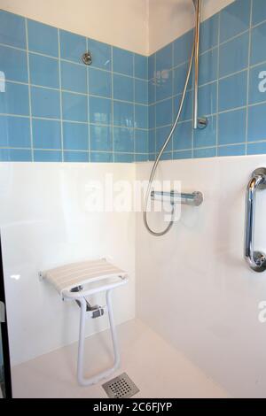 Sedia per doccia per disabili per anziani o disabili con maniglia a barra in casa, concetto di sicurezza Foto Stock
