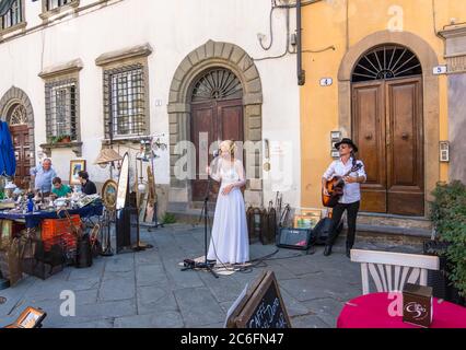 Lucca, Italia - 17 agosto 2019: Artisti che si esibiscono in una tradizionale fiera dell'antiquariato nel centro storico di Lucca, Toscana Foto Stock