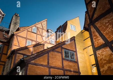 Case con travi in legno dipinte di giallo e arancio a Copenhagen, Danimarca Foto Stock