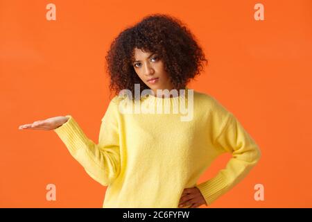 Cosa non mi interessa. Unbothered e spensierata non impressionati broncio AFRICAN-AMERICAN donna con capelli ricci, di alzare la mano in sgomento dispiaciuto con bad Foto Stock