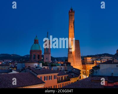 Torre Asinelli e il suo vicino più corto, la Torre Garisenda. Illuminato di notte. Bologna, Italia. Foto Stock