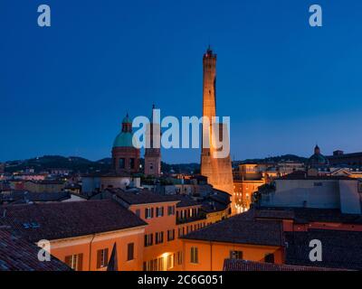 Torre Asinelli e il suo vicino più corto, la Torre Garisenda. Illuminato di notte. Bologna, Italia. Foto Stock