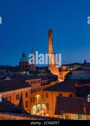 Torre Asinelli e il suo vicino più corto, la Torre Garisenda. Illuminato di notte. Bologna, Italia. Foto Stock