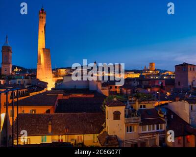 Torre Asinelli e il suo vicino più corto, la Torre Garisenda. Illuminato di notte. Bologna, Italia. Foto Stock