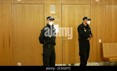 Maschera coronavirus faccia respiratoria Consiglio ceco Città Olomouc due poliziotti di polizia ufficiali di guardia la porta del consiglio sala riunioni persone donna Foto Stock