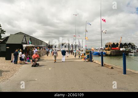 I turisti possono godersi una giornata fuori a Whitstable Bay e al porto, Whitstable, Kent, Inghilterra, Regno Unito Foto Stock